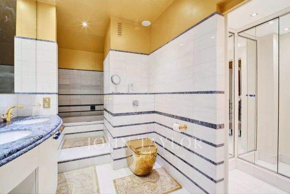 Avenue Montaigne : Salle de bain élégante avec grande baignoire, finition en marbre et nombreux placards