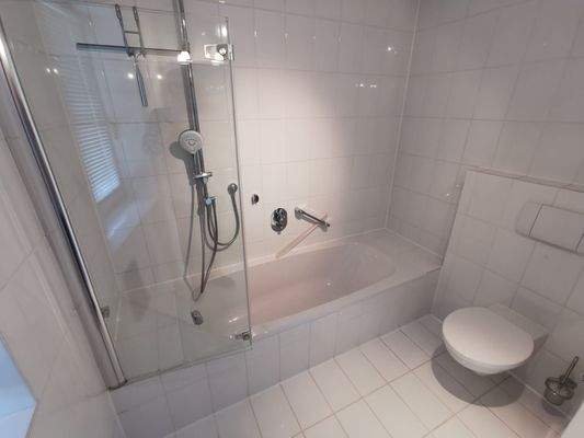 EG: Bad/WC der Einliegerwohnung mit Badewanne und integrierter Dusche