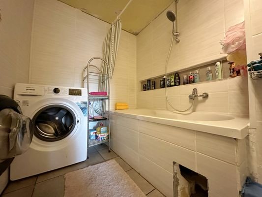 Badezimmer mit Wanne und Waschmaschinenanschluss