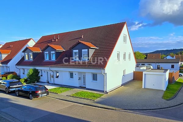 Frontansicht des Hauses mit Garage und Stellplätzen