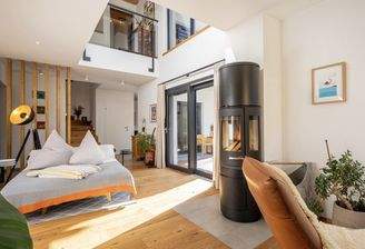 Der Luftraum mit Galerie bringt zusätzliches Licht ins Wohnzimmer.