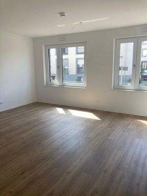 Wohnzimmer mit Boden in Holzoptik, zwei Doppelfenster mit Blick auf die Straße