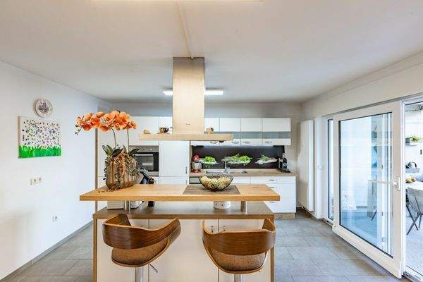 moderne Wohnküche mit Insel und grosser Schiebetür