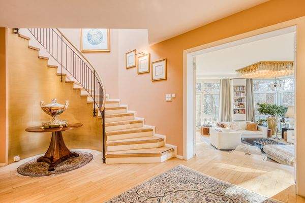 Repräsentatives Entrèe mit geschwungener Treppe zum Dachgeschoß und fließender Verbindung zum Wohnbereich