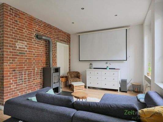 Blick zu Kamin und Leinwand