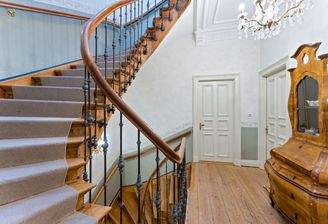 Charmantes Treppenhaus mit geschwungenem Holzgeländer