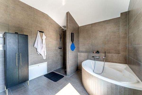 Badezimmer mit Eckbadewanne und Dusche