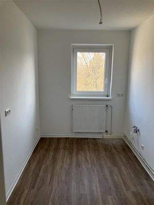 Küche mit Fenster, Fußboden in Holzoptik und Fenster, Heizkörper unter dem Fenster 