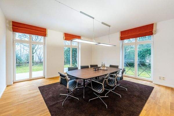 Repräsentatives Besprechungszimmer mit Blick ins Grüne und direktem Zugang zur Terrasse – perfekt für Meetings in entspannter Atmosphäre