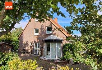 Hausgiebelseite mit Runderker und Gartenhaus