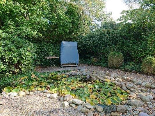 Sitzgelegenheit mit Strandkorb am Teich