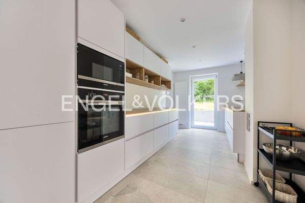 Moderne Küche mit hochwertigen Geräten, angrenzender Speisekammer und direktem Gartenzugang