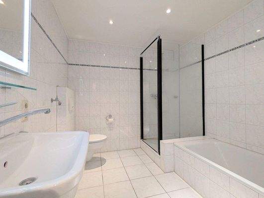 Badezimmer mit Badewanne und Dusche.