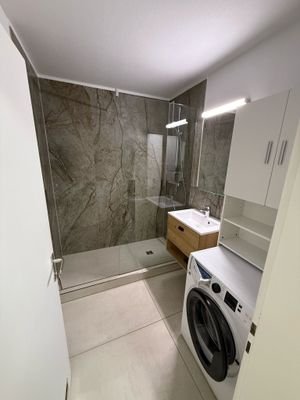 Bad mit großer Dusche und Waschmaschine