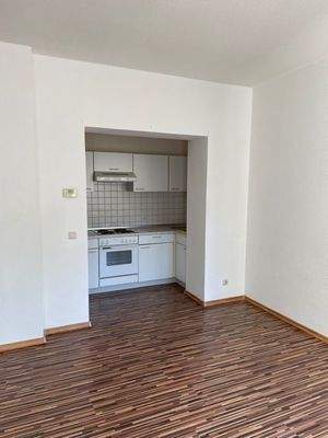 Wohnzimmer mit offener Einbauküche