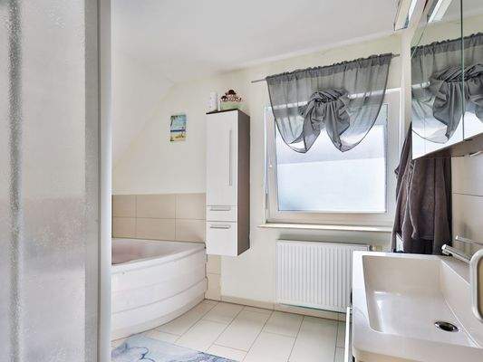 Tageslichtbad mit Eckbadewanne und Dusche im Obergeschoss