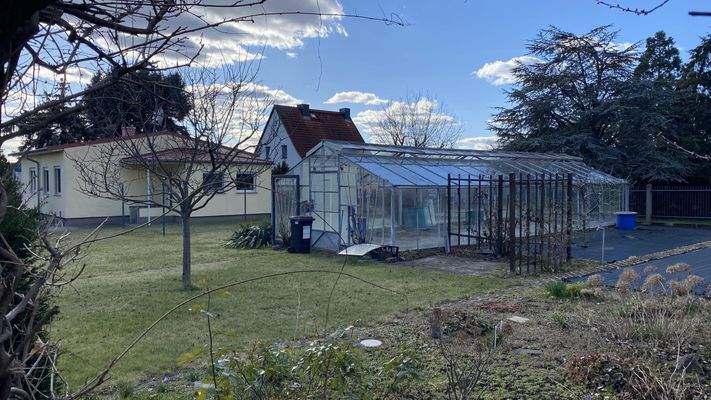 Blick vom Garten mit großem Gewächshaus