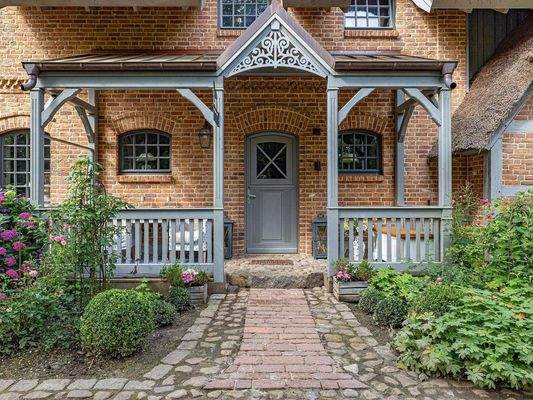 Eingang der Eigentümer-Haushälfte mit Holzveranda