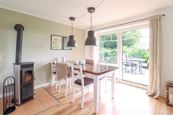 Esszimmer mit Ofen und Zugang zur Terrasse