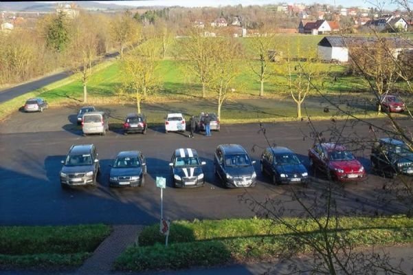 Großer Parkplatz links vom Gewerbegebäude
