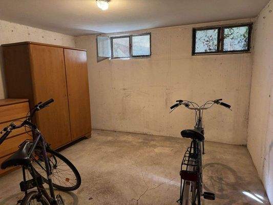 Kellerraum mit Schrank und zwei Fahrrädern