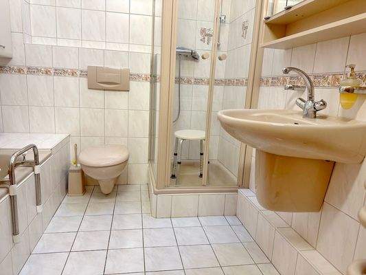 Das helle Bad mit Fenster, Wanne und Dusche.