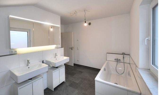 großes Badezimmer mit Badewanne, Dusche und abgeteiltem WC