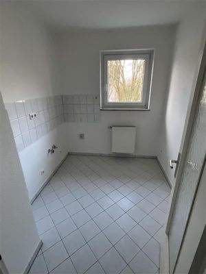 Küche mit weißem Fliesenspiegel, weißen Bodenfliesen und Fenster