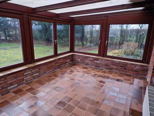 Wintergarten mit Ausblick in den gepflegten Garten