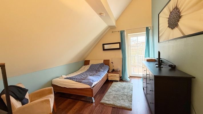 Schlafzimmer im Obergeschoss mit Zugang zum Balkon