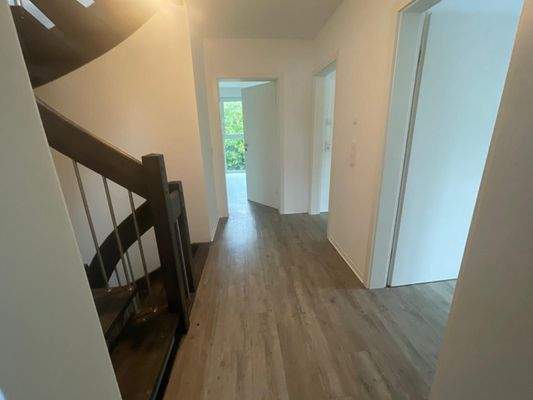 Heller Flur mit Holztreppe